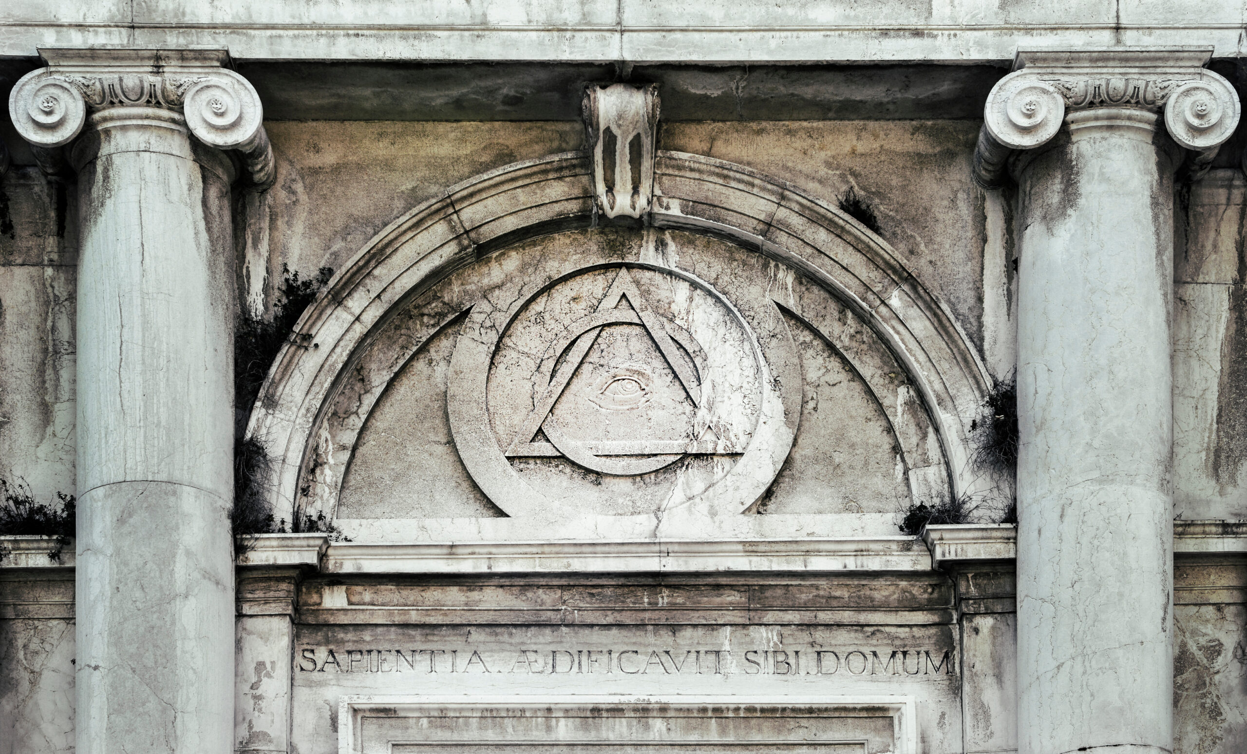 Eye of Providence, inside triangle interlaced with circle above doorway of building in Venice, Italy - It represents the eye of God watching over humanity, or divine providence.